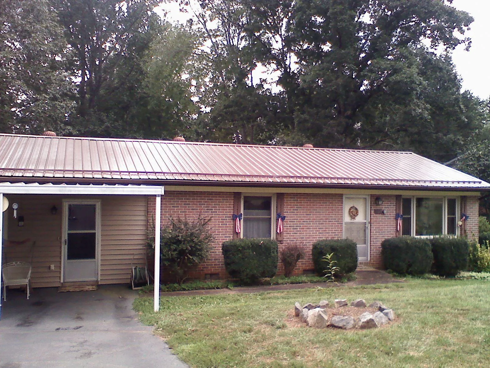Bronze metal roof and carport on a brick ranch home — Roof Repair work by our crew in Camanche